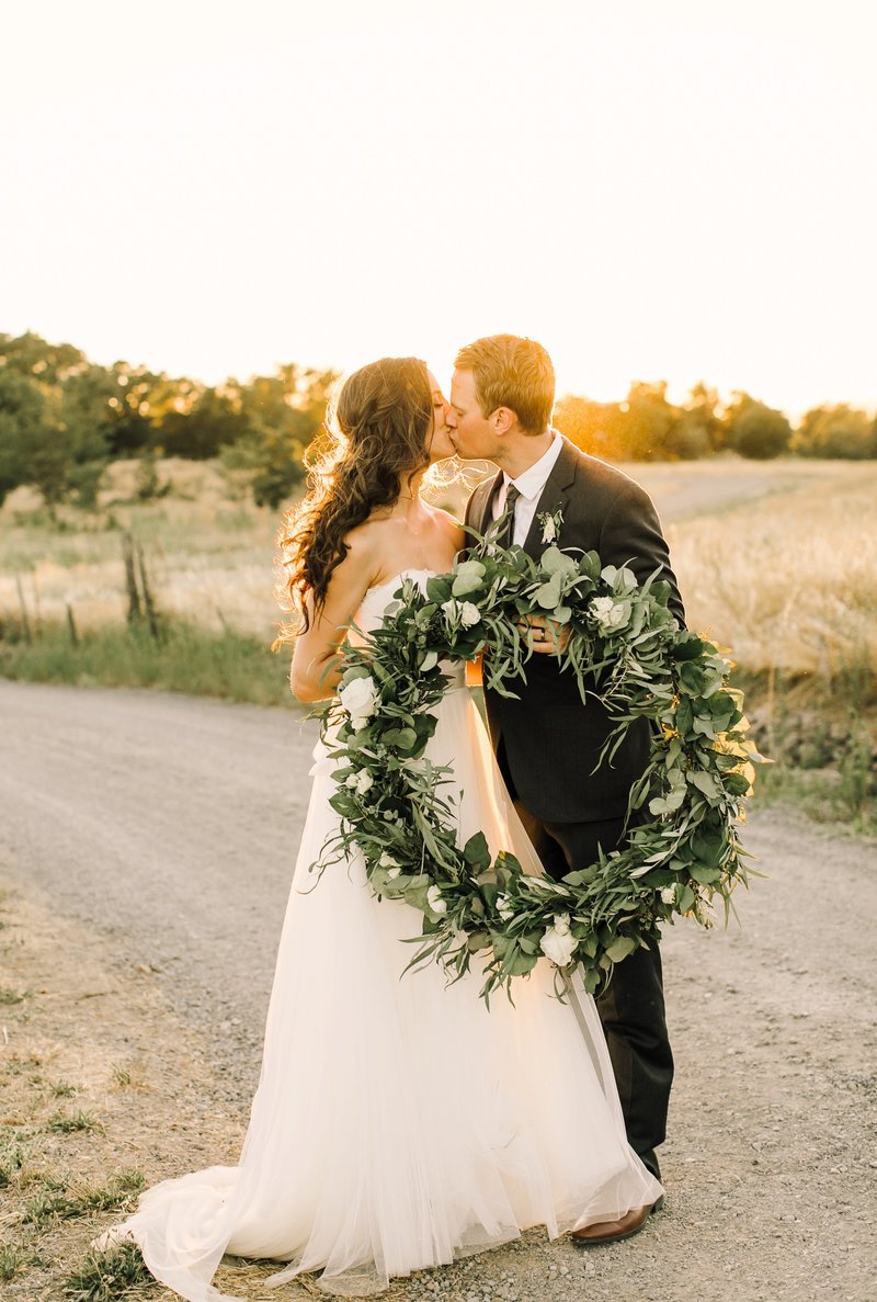 Wedding Photography, couple holding a large wreath of greenery
