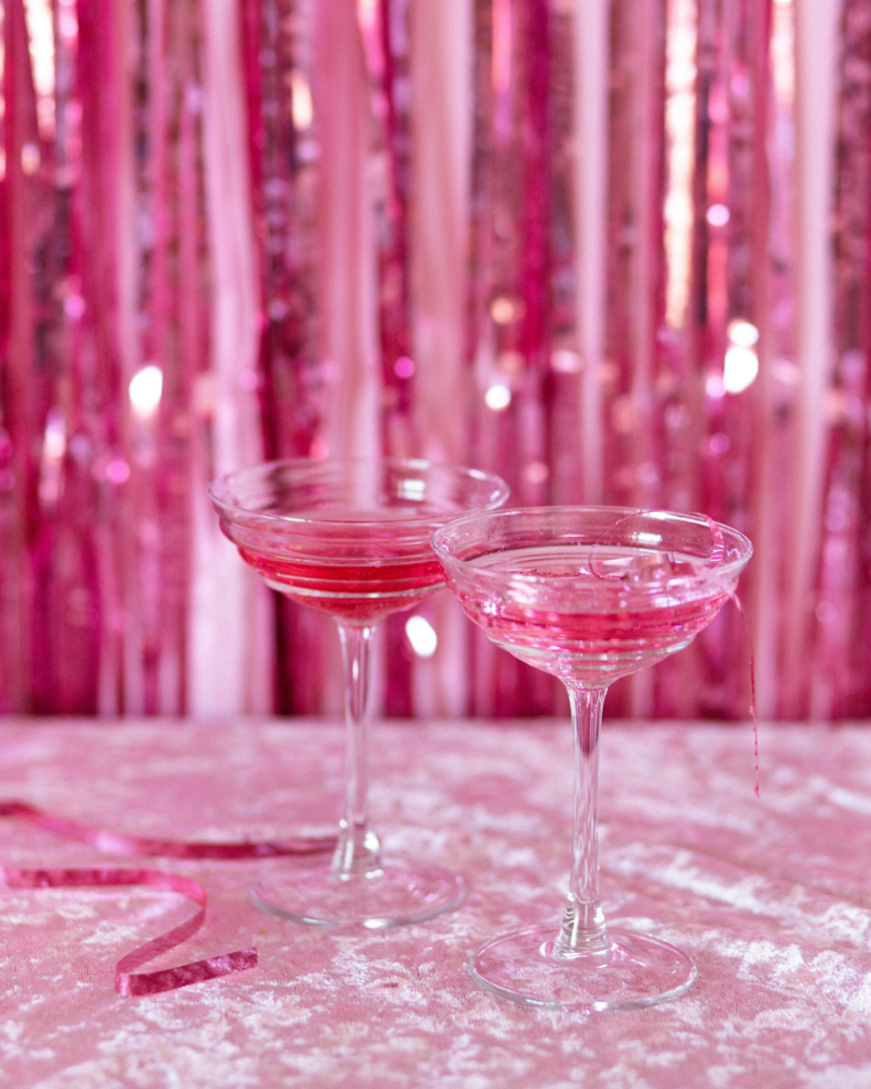 two champagne glasses filled with pink liquid