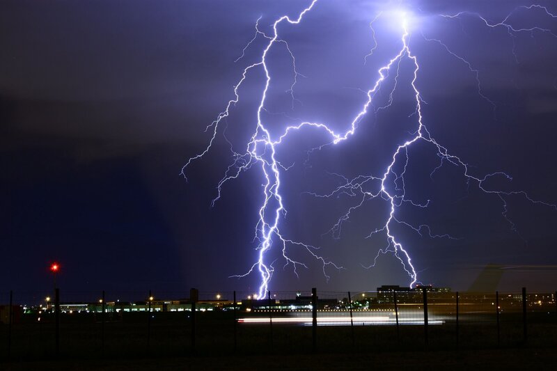lightning striking the earth near buildings
