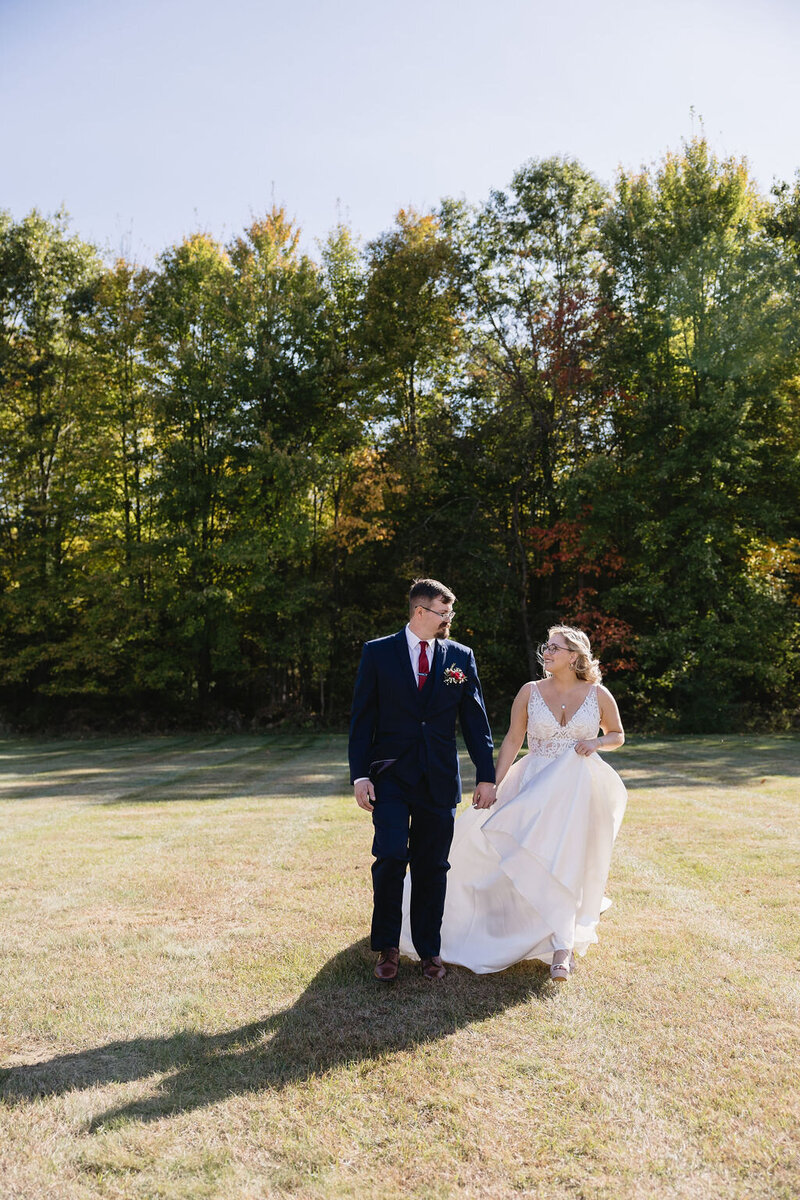 newly married couple walking to wedding reception outdoors
