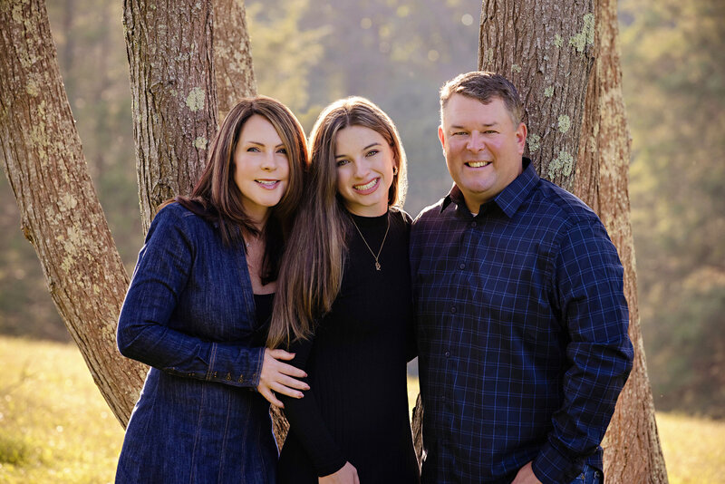 Family portraits are cherished treasures especially for older children. This sweet photograph of a family of 3 in front of tall trees at Anne Springs Close Greenway withe beautiful backlight will definitely be cherished for years to come.