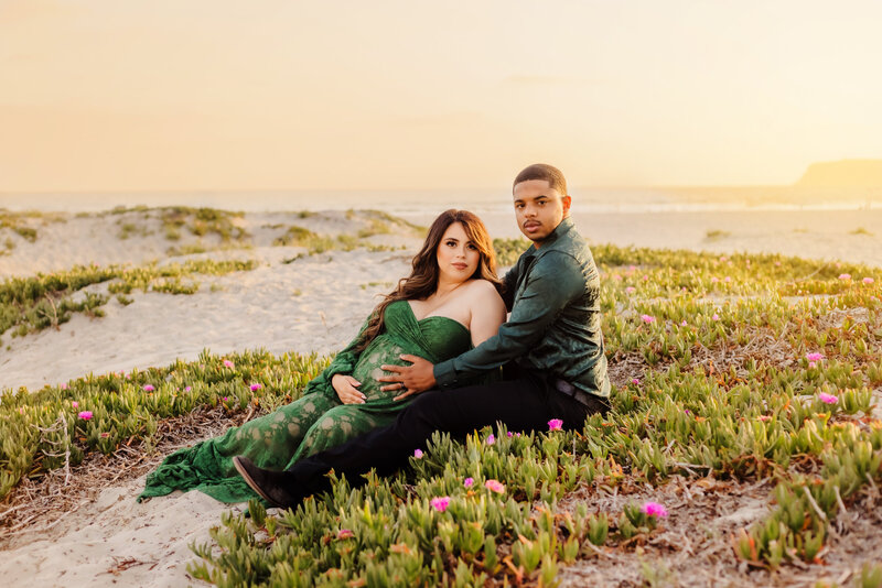 Maternity Photographer, A pregnant woman wears a green maternity gown and stands in the chaparral