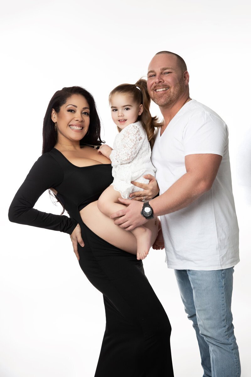 Family with girl hugging baby belly by new jersey family photographer