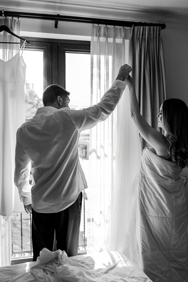 man-and-woman-holding-hands-up-near-window