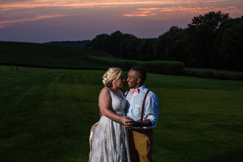 Bride and groom  pose together at sunset at Betsy's Barn