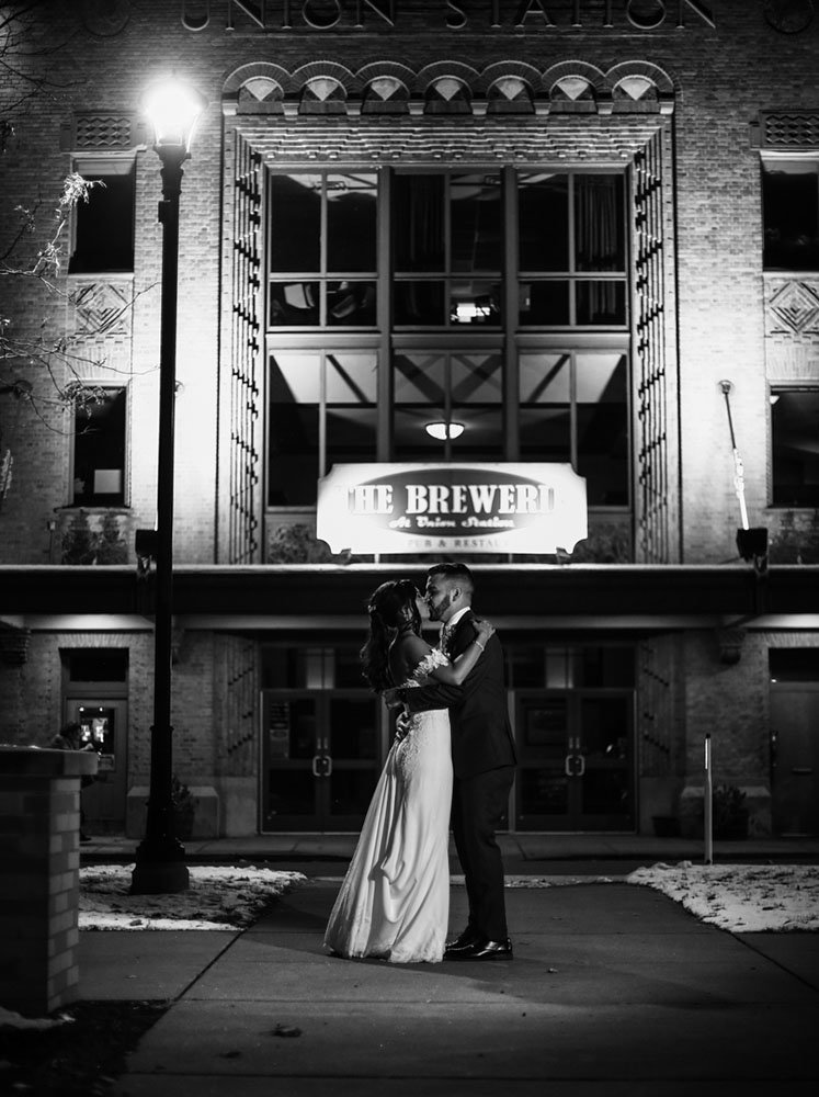 Bride and groom kiss outside the Concourse of Union Station at night in Downtown Erie, PA