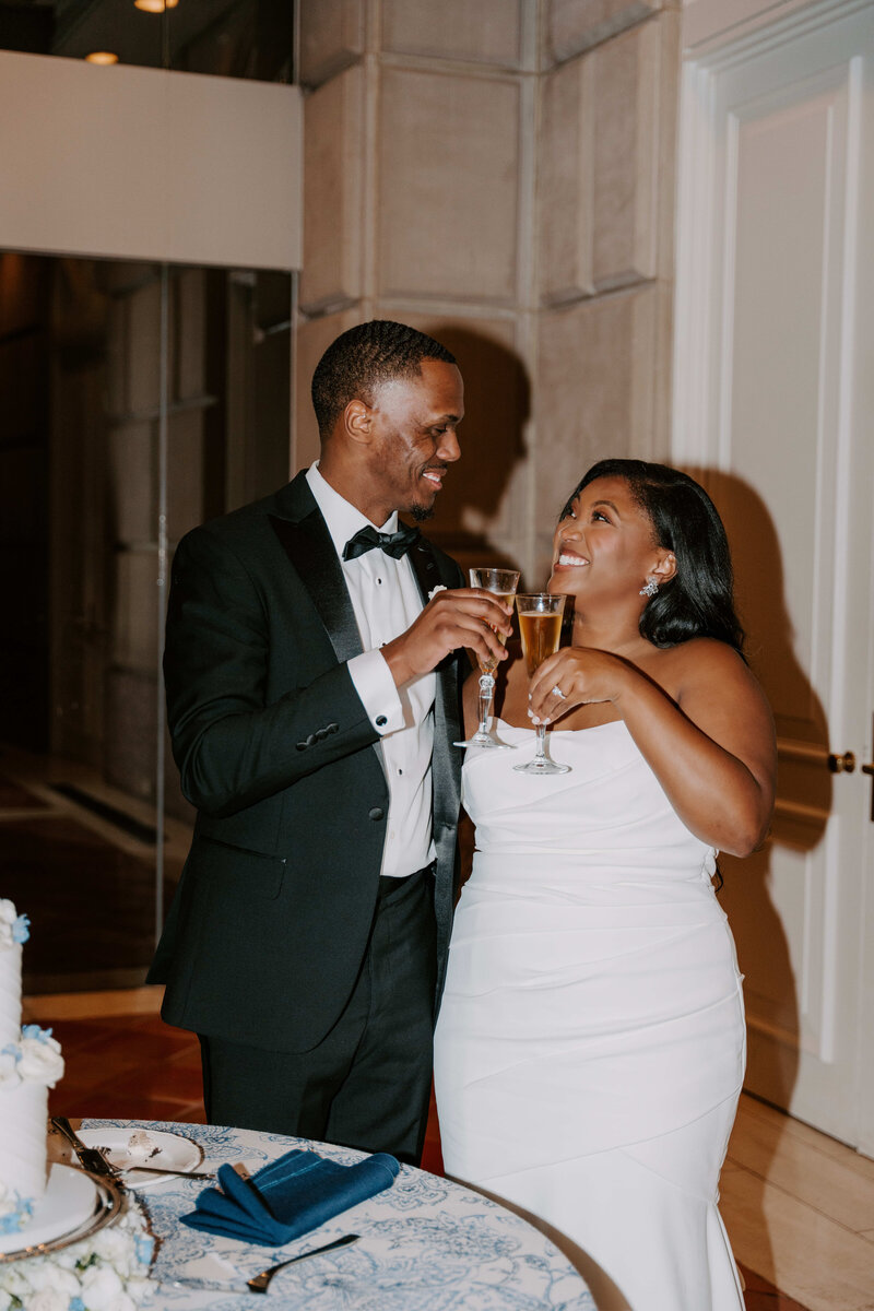 Elegant wedding reception moment of a newlywed couple toasting with champagne