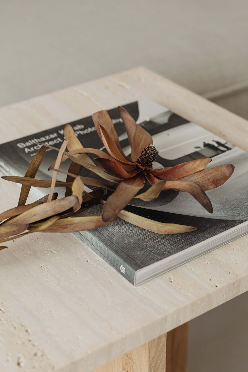 Tami Luger Real Estate |  dried flower resting on coffee table book