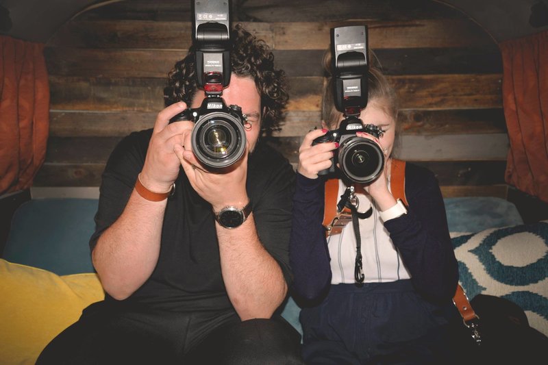 Steven and Stephanie holding cameras looking at the camera