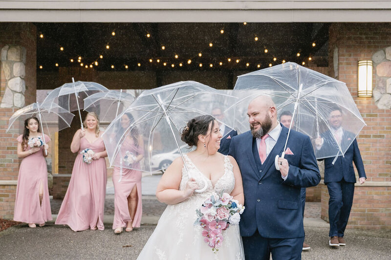 bride and groom smiling on wedding day in the rain