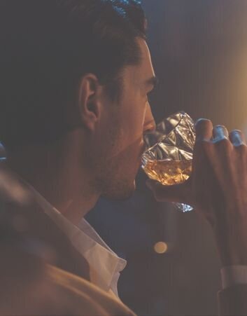 man-drinking-whiskey-from-glassware