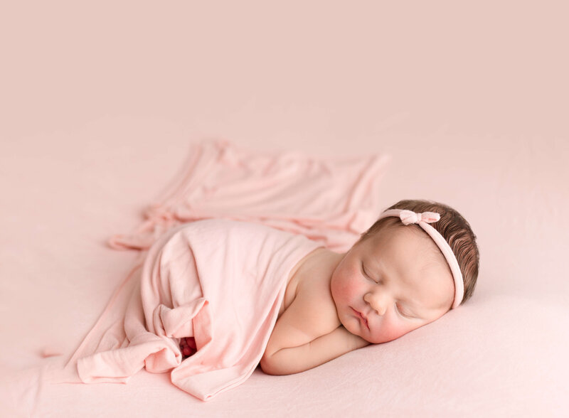 girl on pink fabric with tiny bow headband