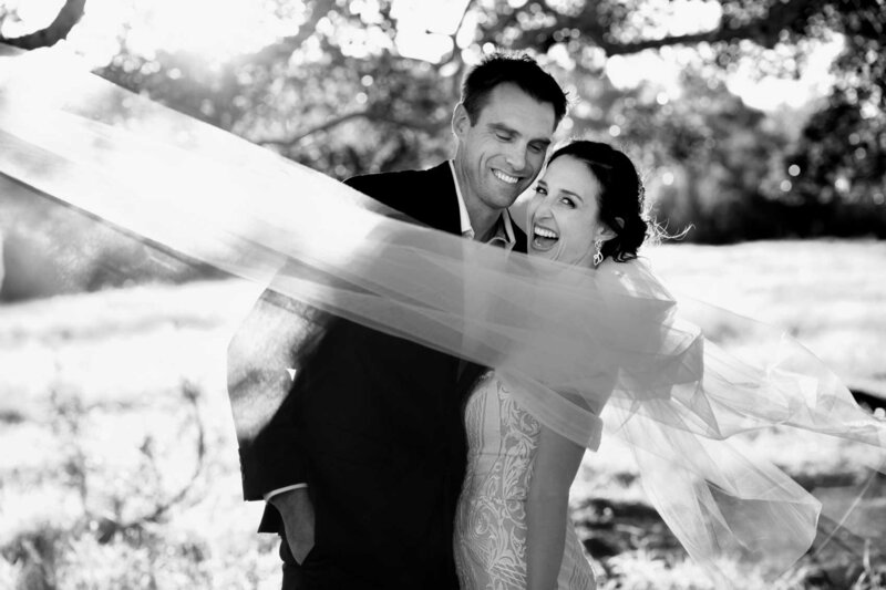 Happy wedding couple close to each other with flying veil