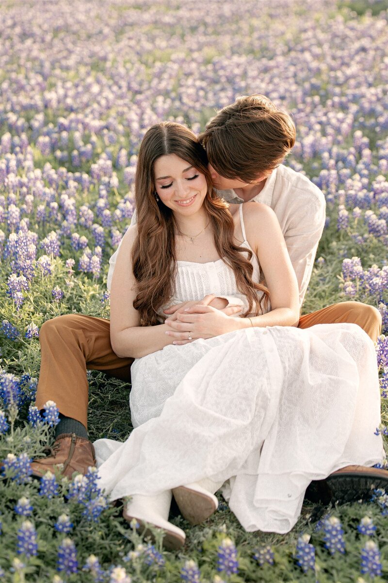 Engaged couple surrounded by bluebonnets by Austin Proposal Photographer