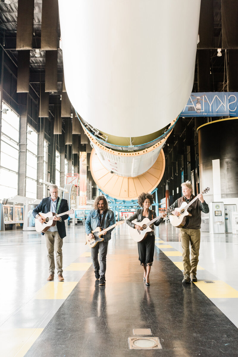 Musicians walking under the Saturn V