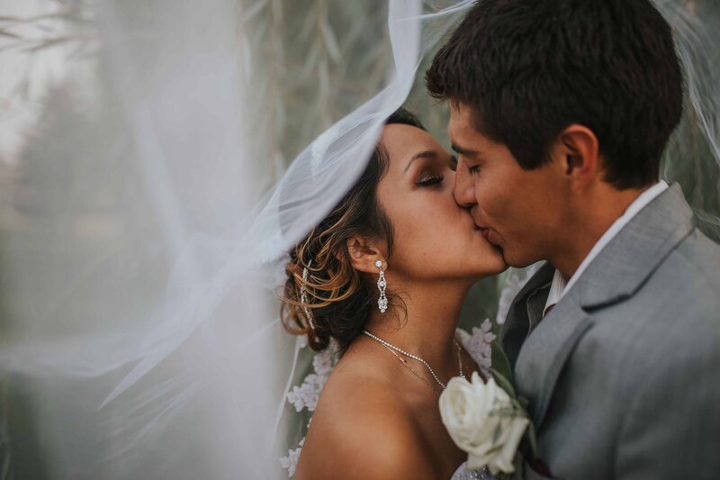 Sacramento Wedding Photographers capture bride and groom kissing under veil