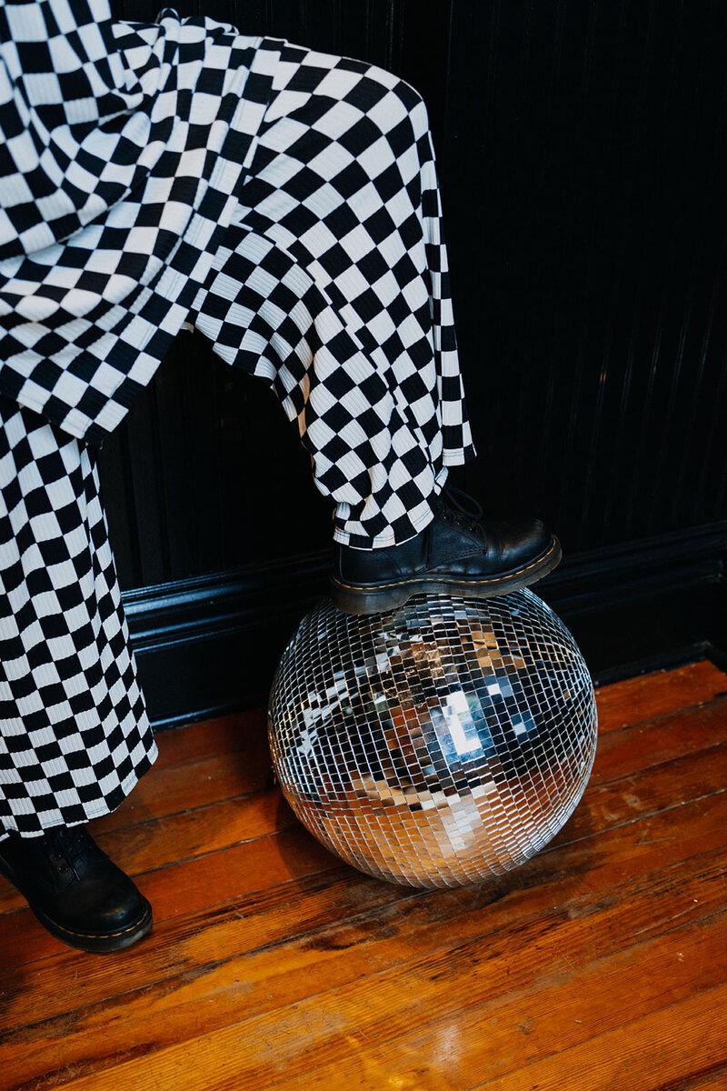 A person resting their foot on a disco ball.