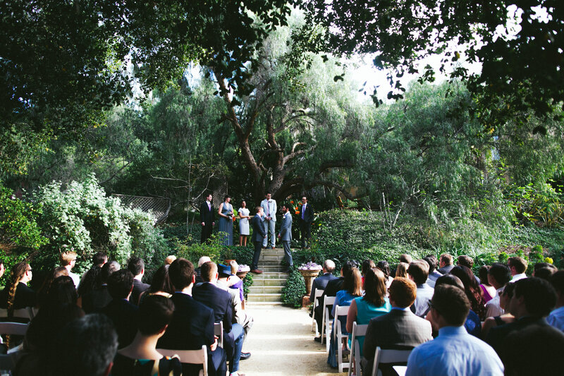 Same sex couple takes their wedding vows under beautiful tree in outdoor wedding ceremony