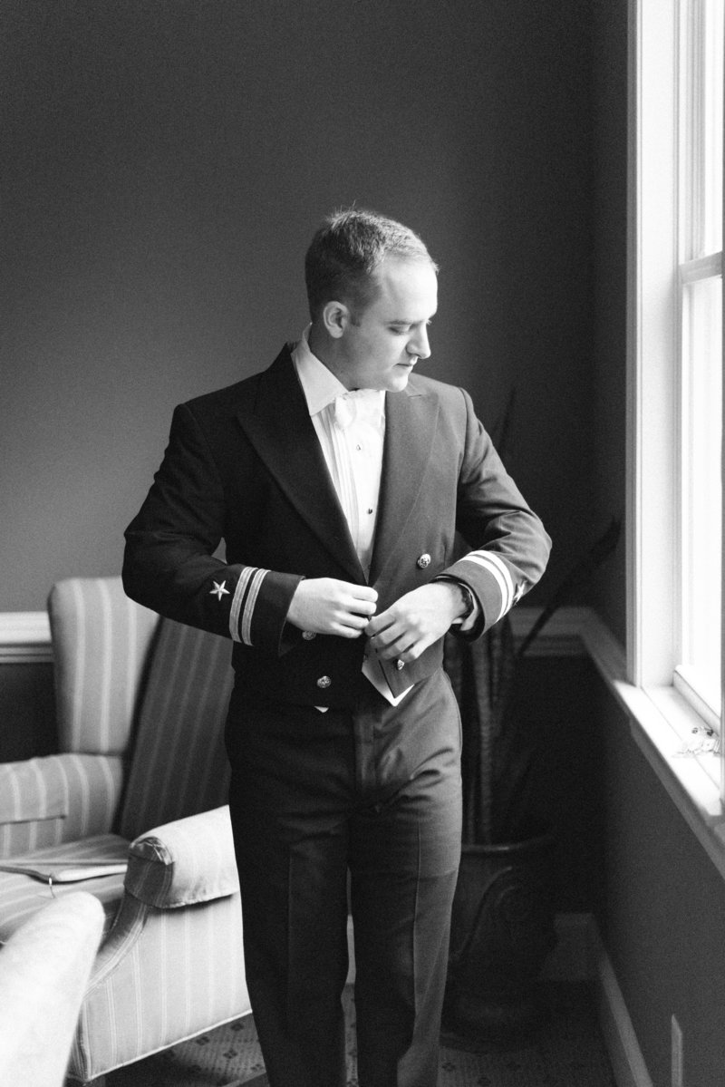 groom getting naval suit on for wedding