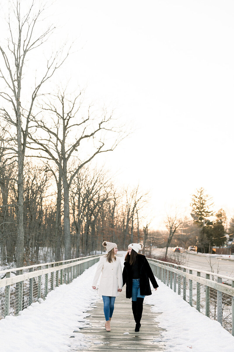 two brides holding hands wearing winter outfits