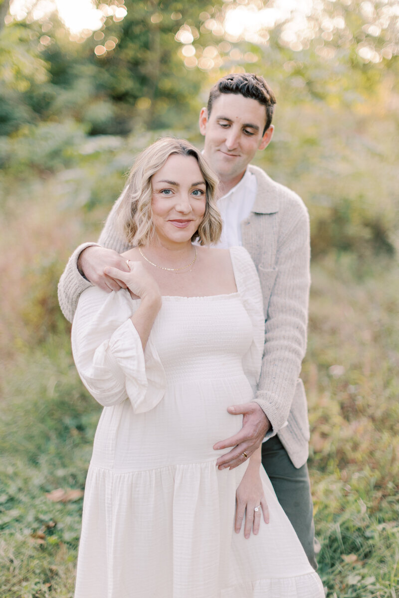 Husband embraces his pregnant wife during maternity portraits