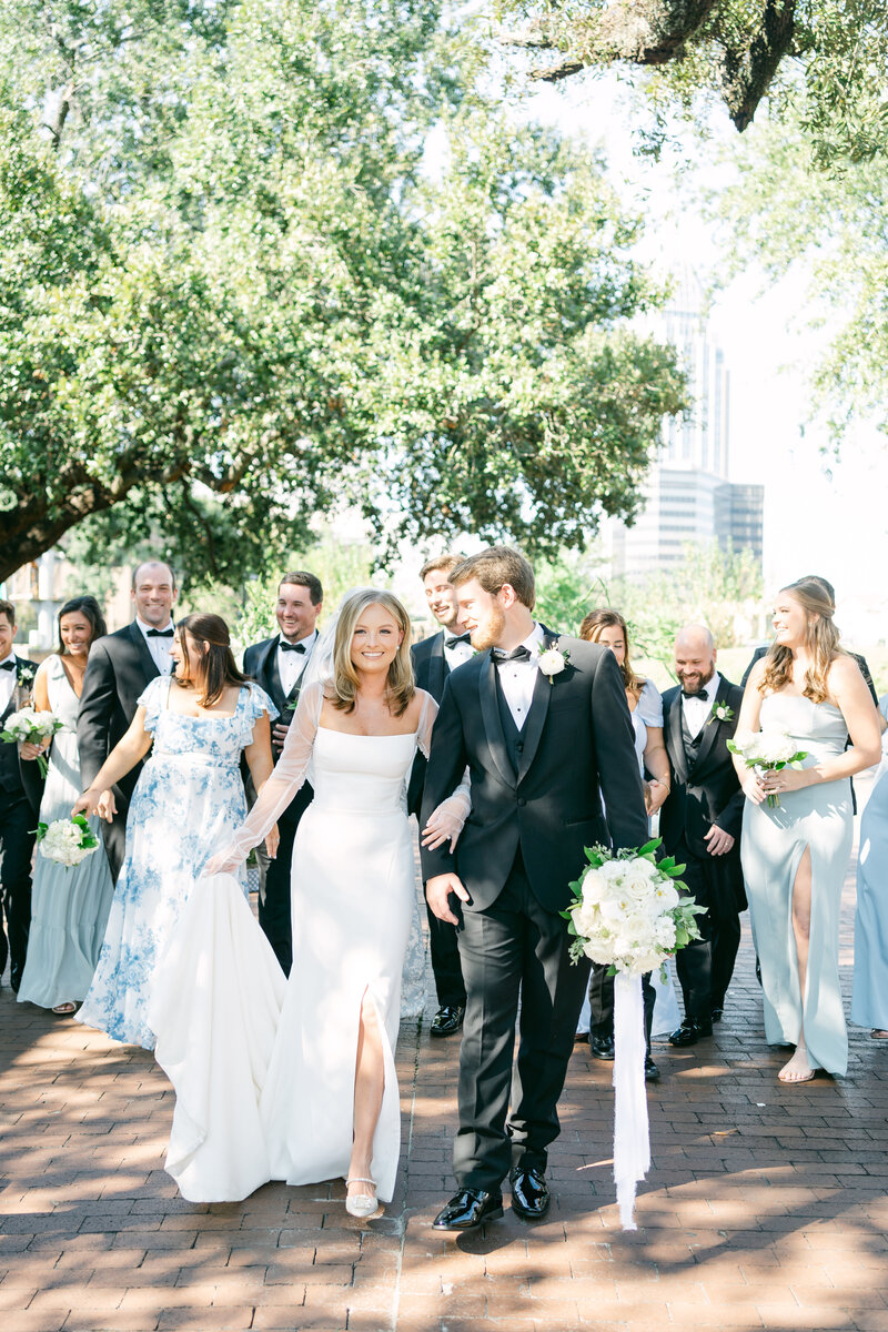 bride and groom walking with brial party for a picture