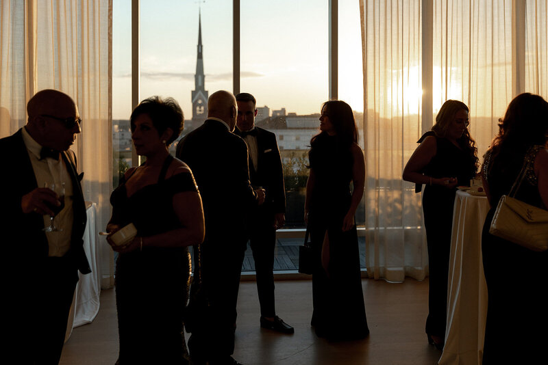 The Dewberry Rivers Room at sunset with wedding guest as dark silhouettes. Charleston Wedding Photographers