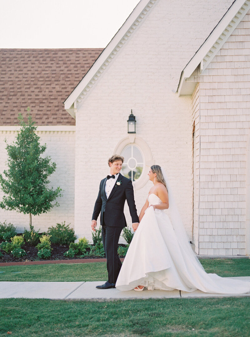Bride and groom walk along path at The Nest at Ruth Farms in Dallas