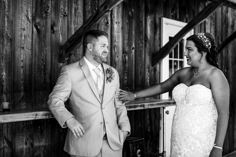 Bride touches groom's arm during first look at Port Farms