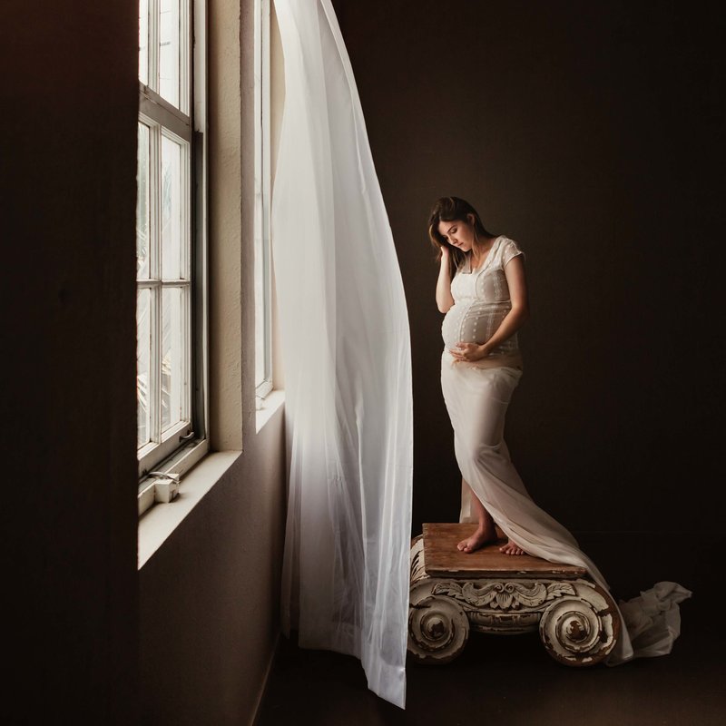Sky 9 Studio | Natural light photography studio in San Francisco East Bay with serene photo of pregnant mother gazing lovingly at belly