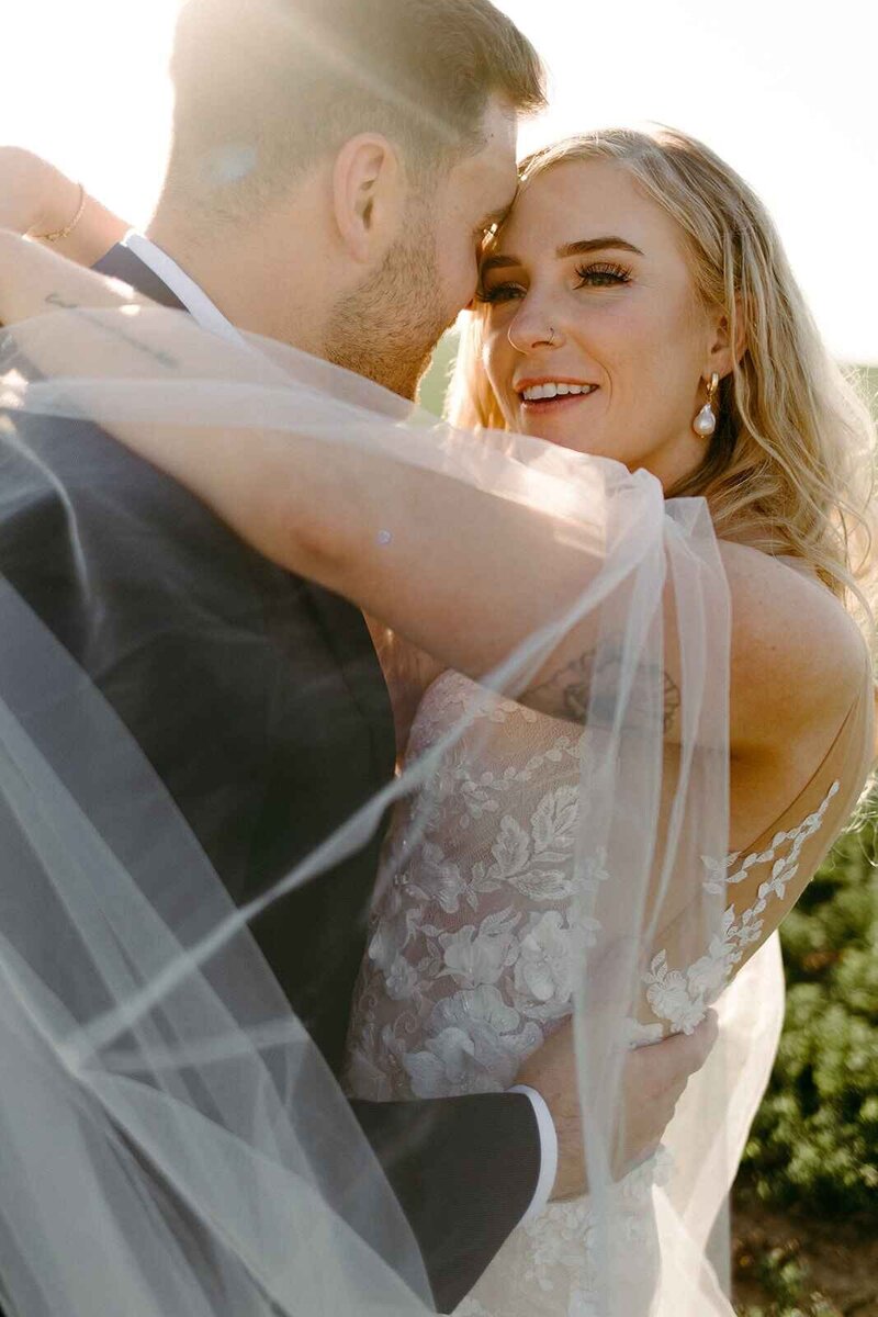 Bride and Groom Embracing in Farm Field - Alex & Jake | Jewel Tone Willow Inspired Wedding Pasco Washington
