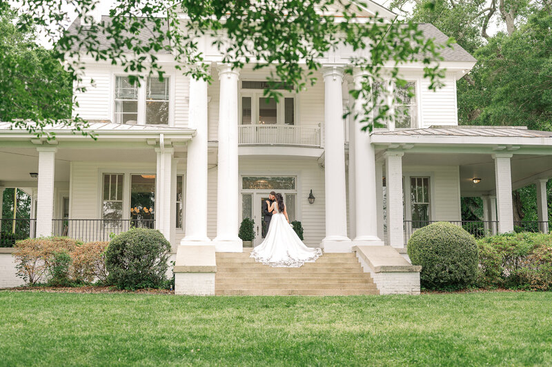 A bride and groom on the porch of their Charlotte wedding venue enjoying their Raleigh wedding photos
