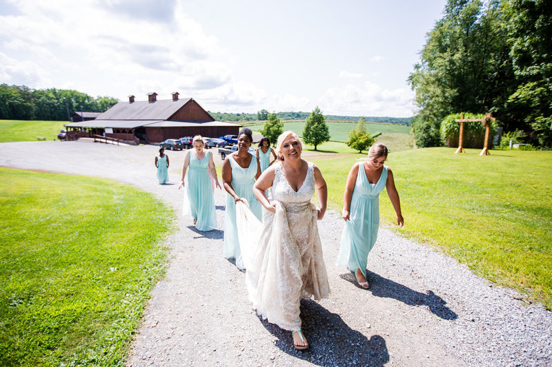 Bride walks the path with her bridesmaids at her Betsy's Barn wedding