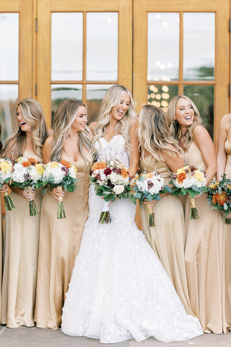 Bride laughs with all of her bridesmaids at Trump Winery