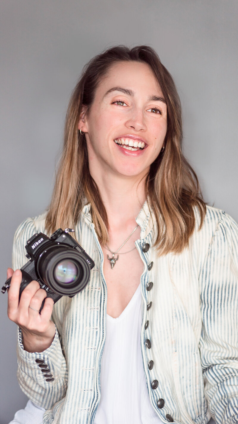 Jimena Adamec holding her camera and smiling