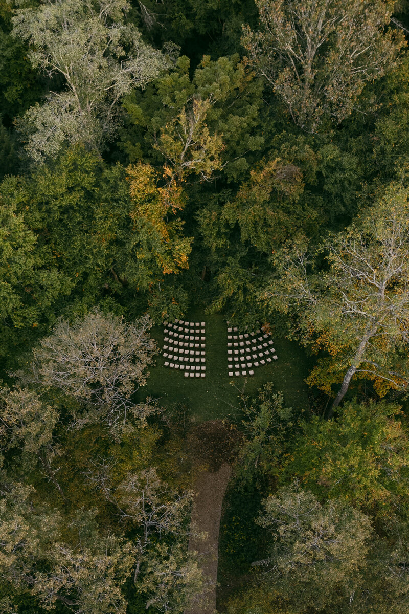 drone photo of wedding ceremony set up amongst the forest 