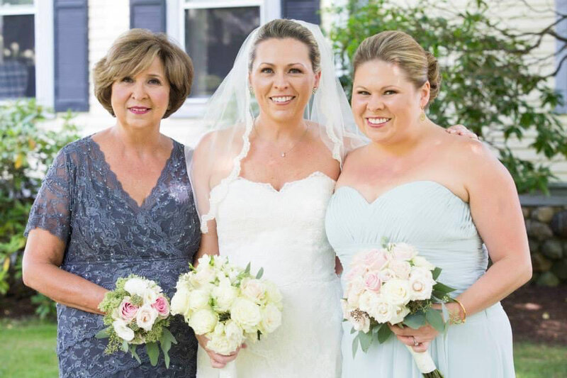 bride posing with mom and bridesmaid after hair and makeup