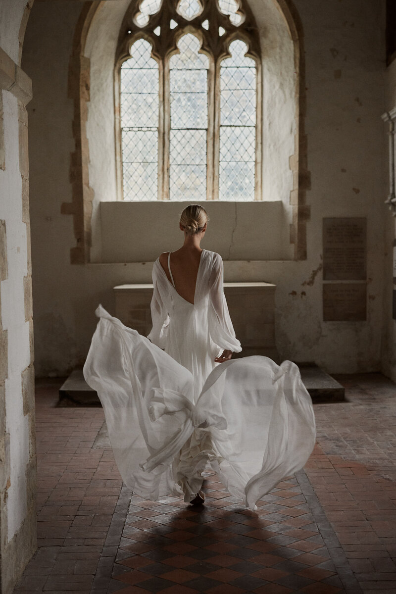 Flowing long silk wedding dress worn by bride in British wedding