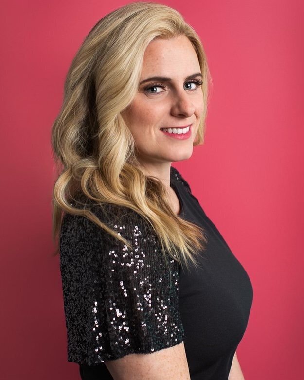 A photo of a blonde woman with curled hair and a sparkly black top with subtle makeup
