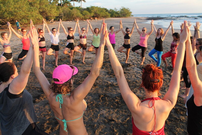Class of Yogis in Costa Rica Practice Tree Pose with hands together