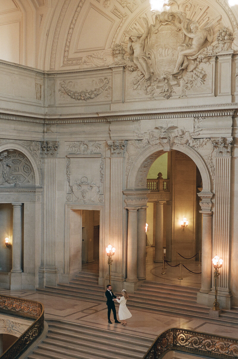 photo of bride and groom holding hands in old building taken by Upstate NY wedding photographer