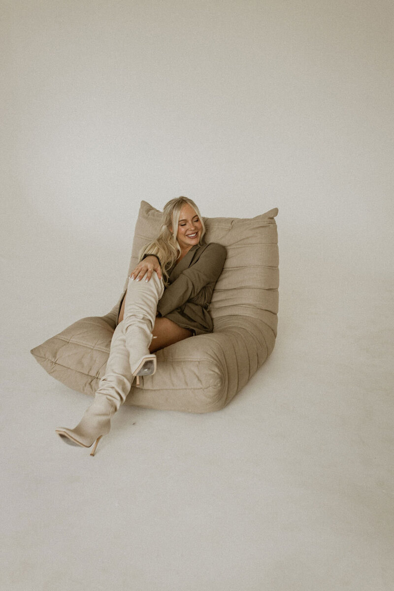 a business coach smiling and sitting on a beanbag chair