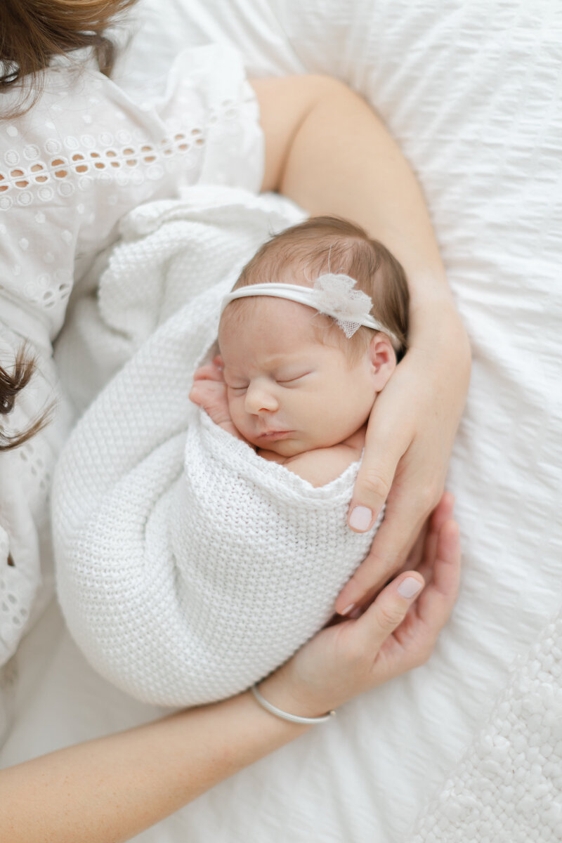 Mother holds her sleeping newborn baby