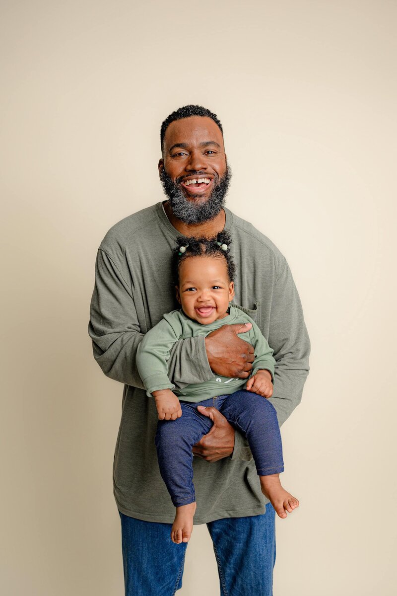 dad holds his one year old daughter for her one year old milestone session