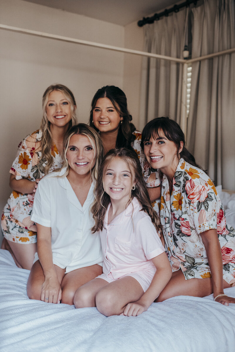 bride and bridesmaids gathered on bed at beaufort inn
