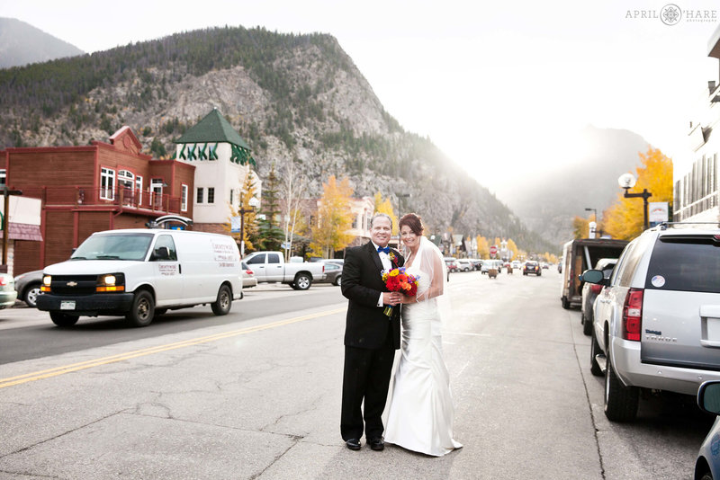 Couple stands on Main Street in Frisco Colorado on their wedding day at 5th Avenue Grill