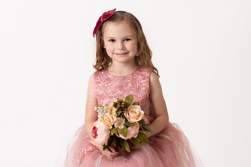 Adorable child in pink dress and flower capture by Houston Photographer