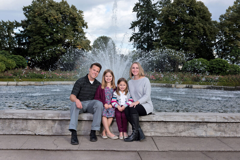 Picture of two parents with two kids at a fountain.