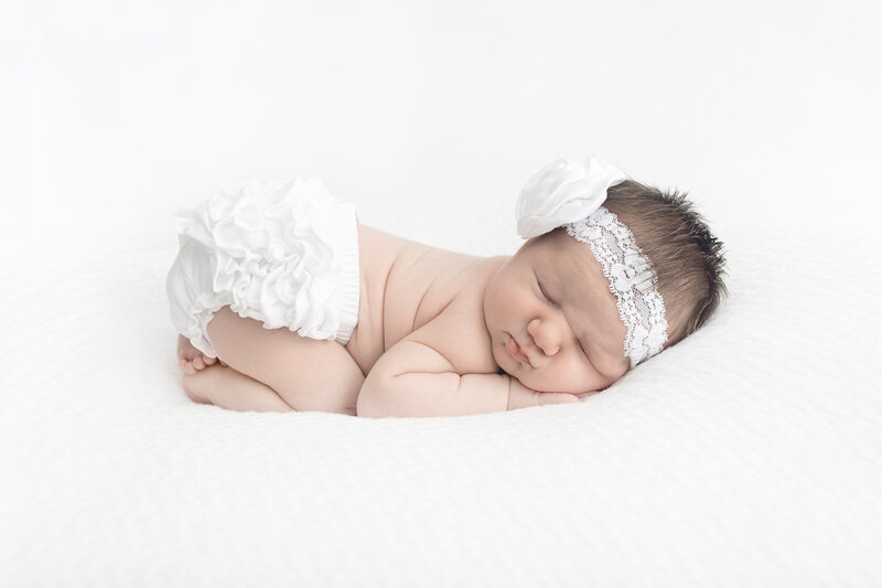 Karen Kahn of Looking Up Photography posed newborn baby girl in white