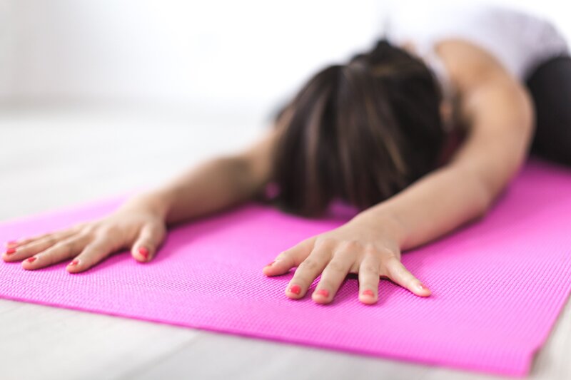 Woman in down dog on pink yoga mat